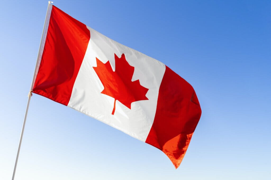 Flag of Canada waving against blue sky