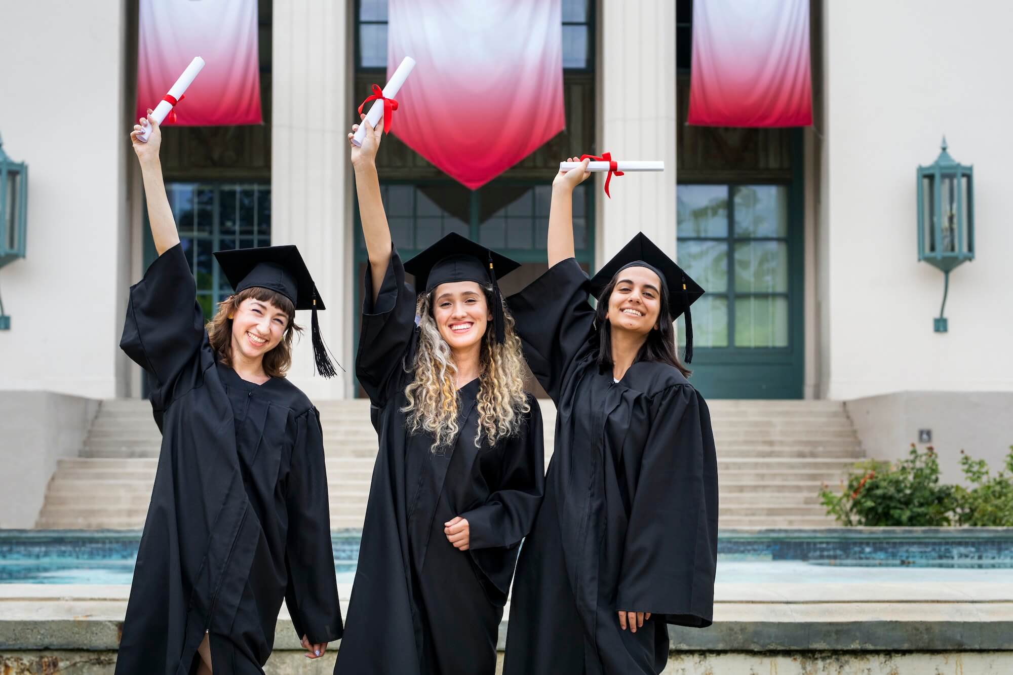 Happy female students graduating university, celebrating with diplomas