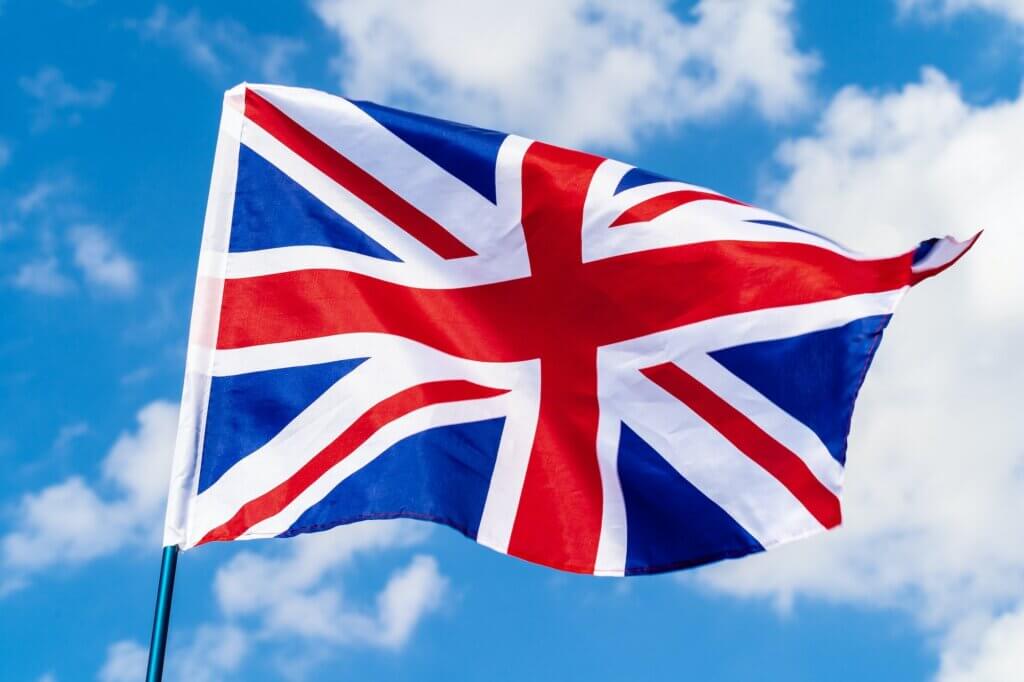 United Kingdom Flag waving on wind in blue sky